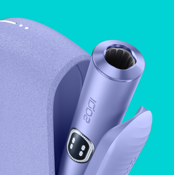 An IQOS ILUMA PRIME Holder with a TEREA stick inserted next to an IQOS ILUMA Pocket Charger.