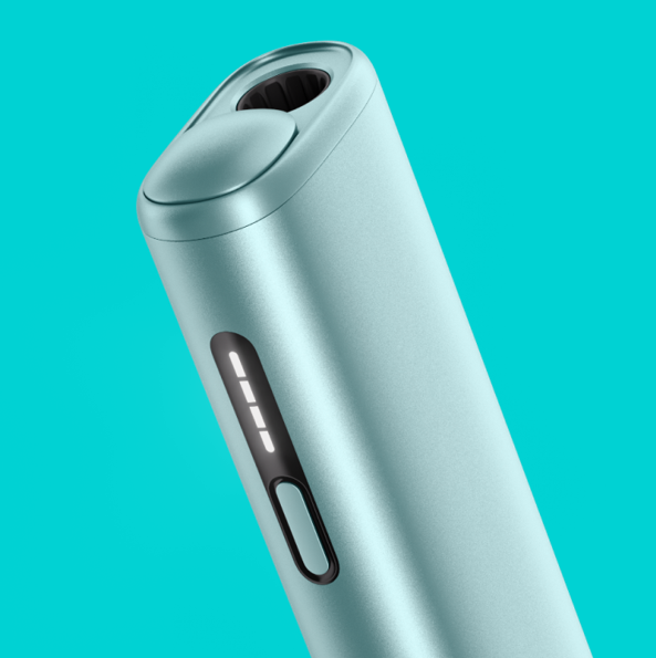 An IQOS ILUMA PRIME Holder with a TEREA stick inserted next to an IQOS ILUMA Pocket Charger.