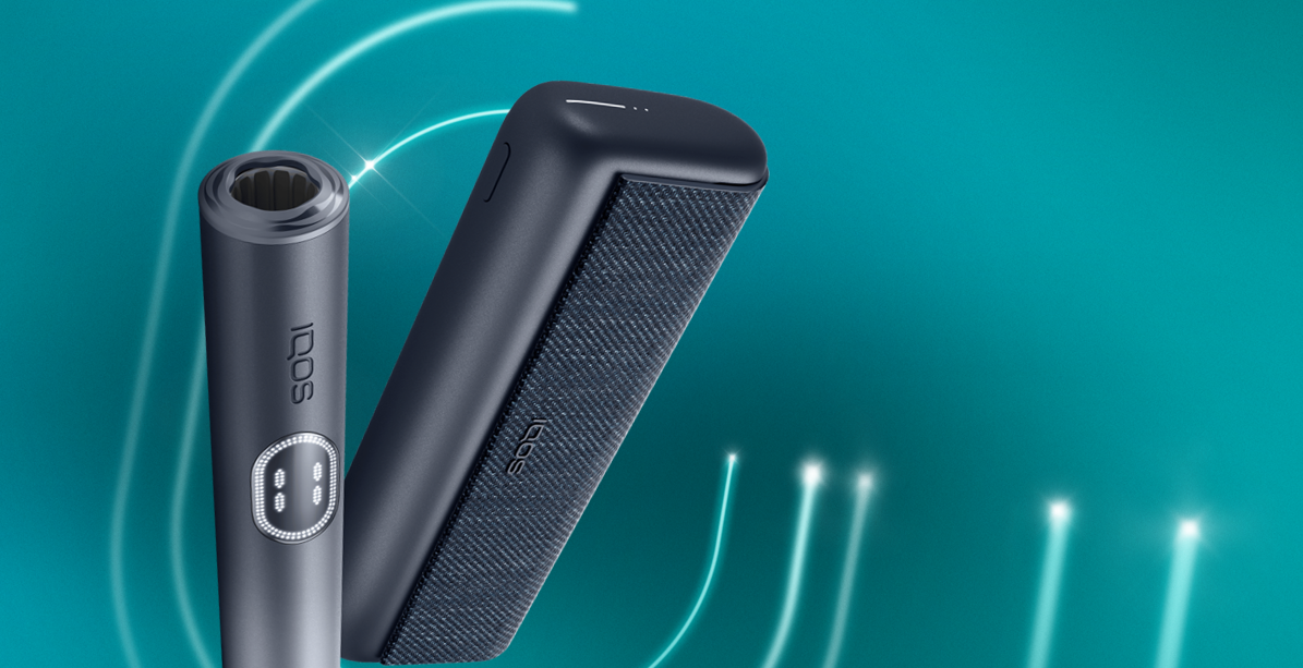 An IQOS ILUMA PRIME Holder with a TEREA stick inserted next to an IQOS ILUMA Pocket Charger.