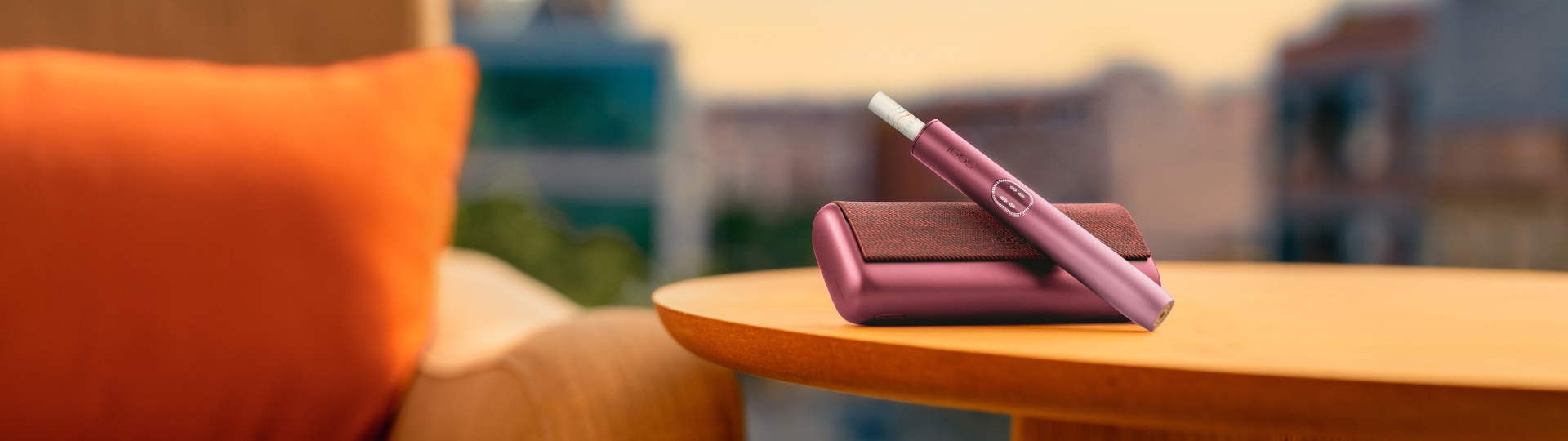 An IQOS ILUMA PRIME Holder with a TEREA stick inserted next to an IQOS ILUMA Pocket Charger.