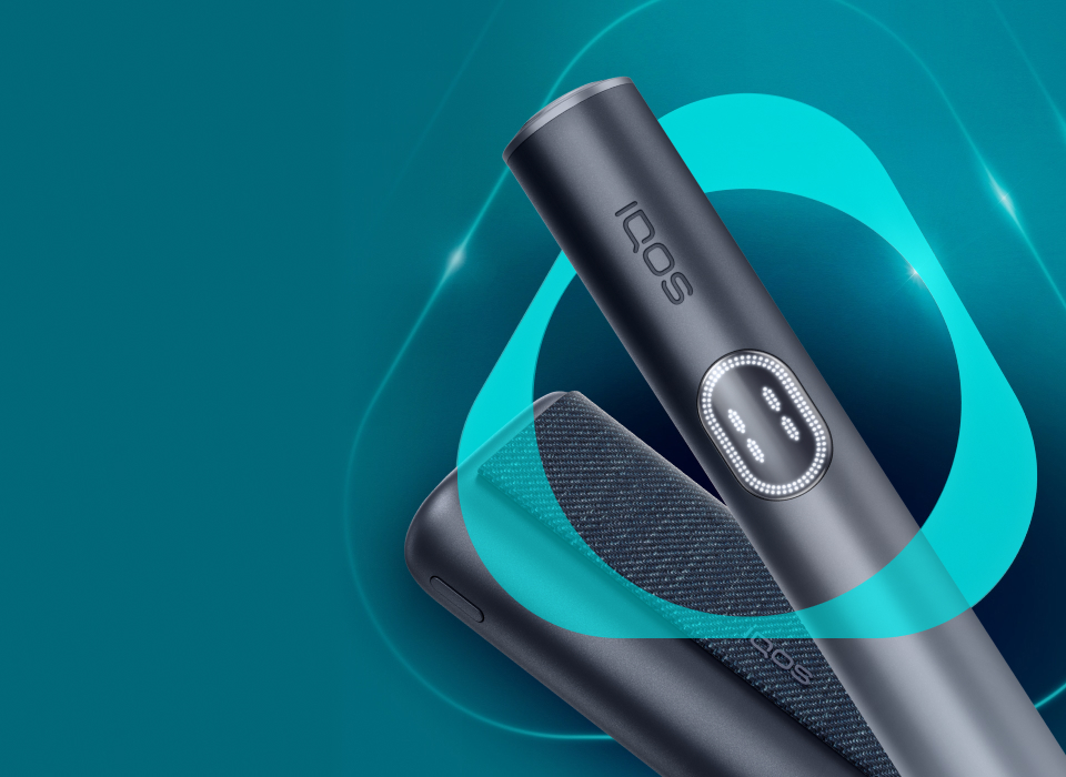 An IQOS ILUMA PRIME Holder with a TEREA stick inserted next to an IQOS ILUMA Pocket Charger.