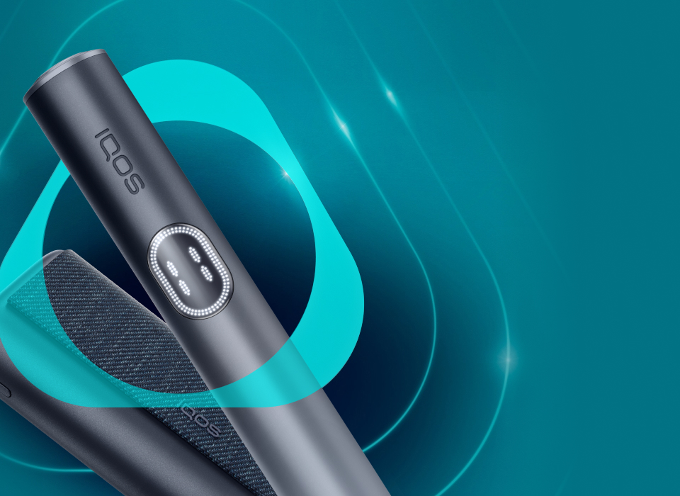 An IQOS ILUMA PRIME Holder with a TEREA stick inserted next to an IQOS ILUMA Pocket Charger.