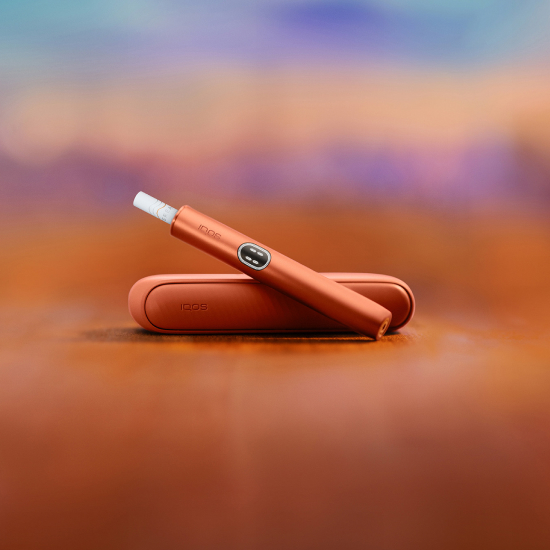 A Jade Green IQOS ILUMA PRIME Holder in a charging station.