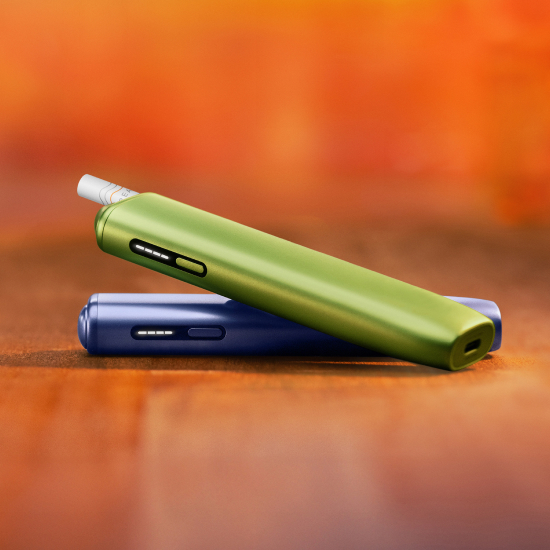 A Jade Green IQOS ILUMA PRIME Holder in a charging station.