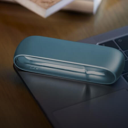 Turquoise IQOS Originals Duo device on a laptop.
