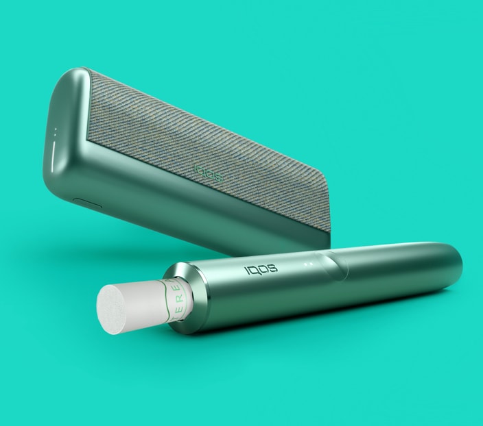 A jade green IQOS ILUMA PRIME holder and a matching device with a TEREA stick inserted.