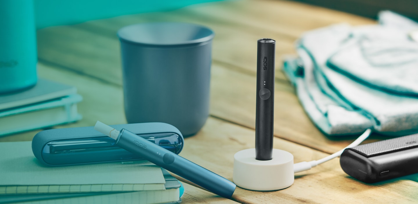 An IQOS ILUMA Pocket Charger and Holder, a charging station and an IQOS  tray.