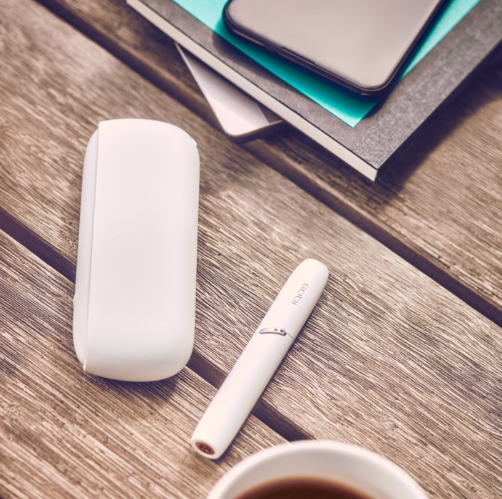 Man with white IQOS holder in his hand