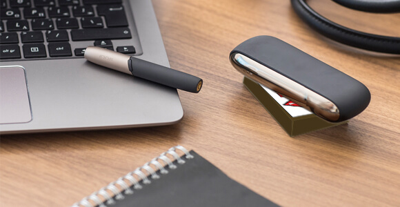 A package containing a gold IQOS device and holder.