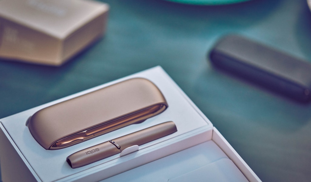 Girl with a flight ticket, an IQOS device and a passport in her hand