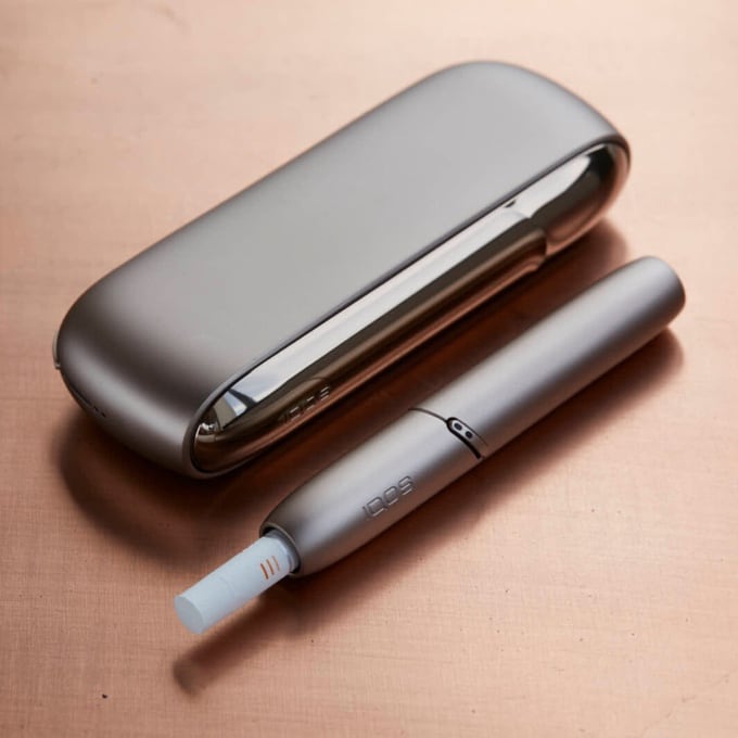 Brilliant gold IQOS 3 DUO holder in its charger.