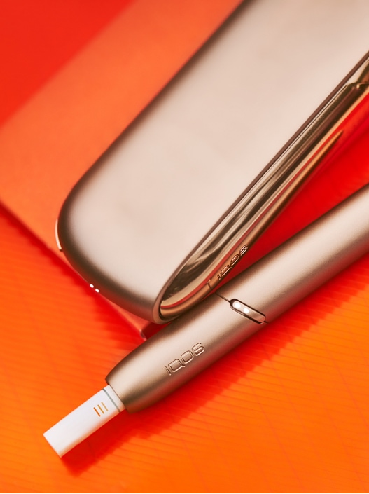A gold IQOS device and holder.