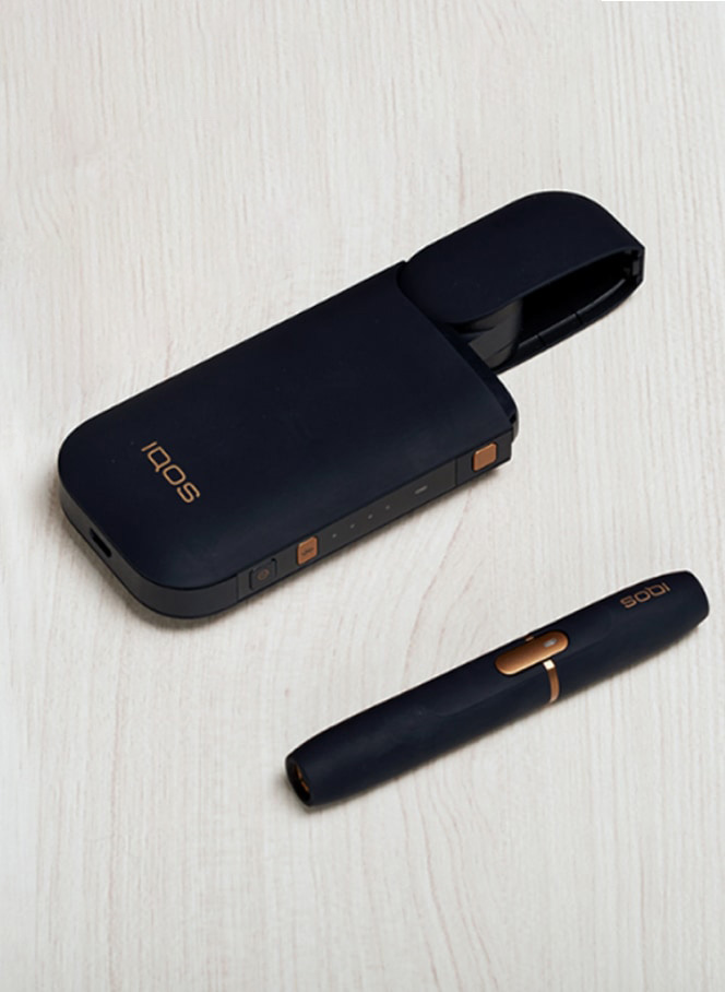 Man with a gold IQOS Duo and a mobile in his hands