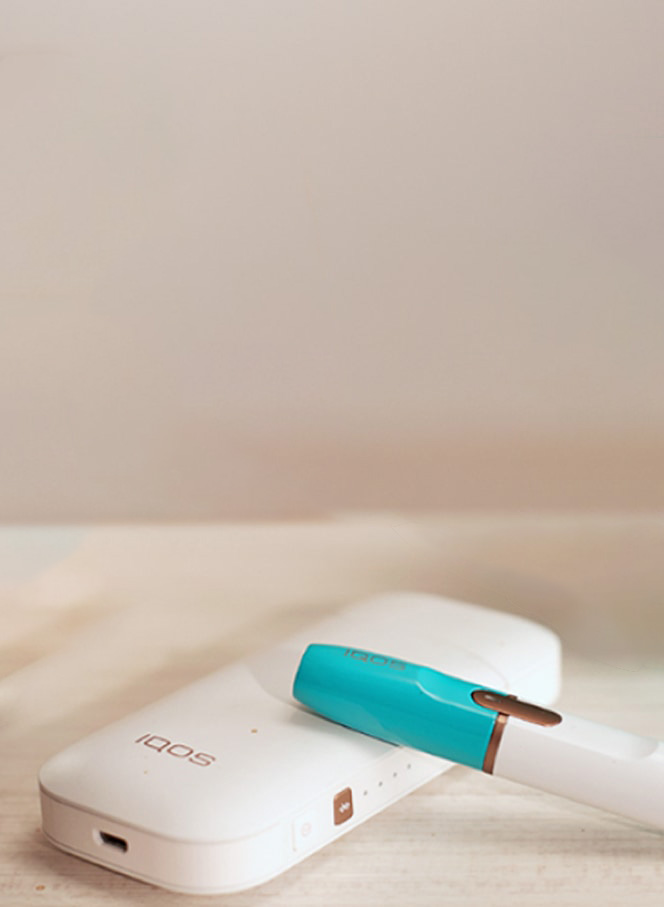 Disassembled IQOS holder, charger and other accessories on a table