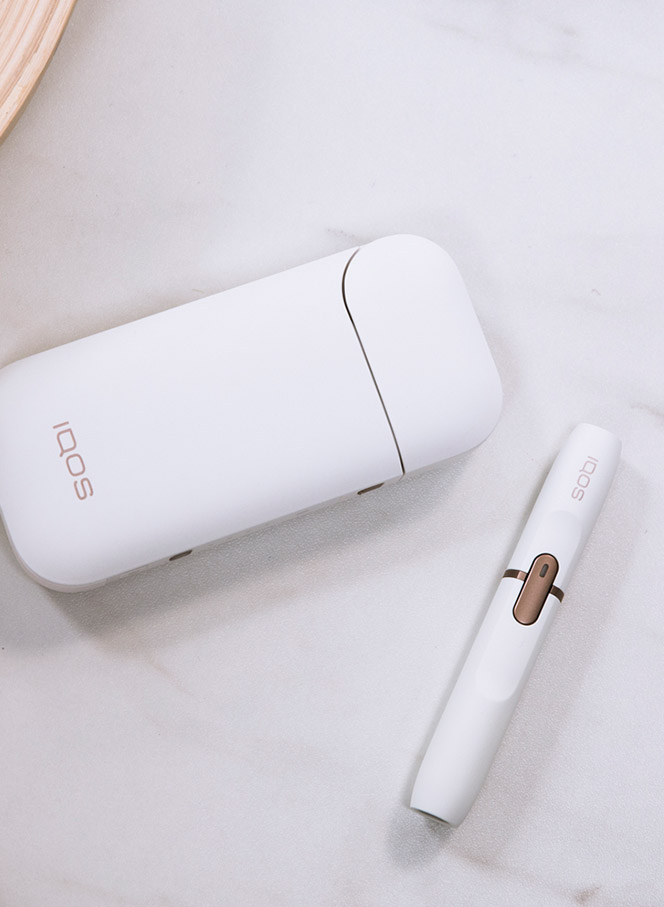 Man with a gold IQOS Duo and a mobile in his hands