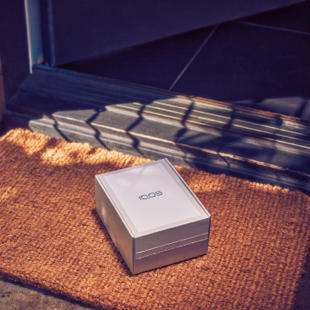 Girl smiling with an IQOS box in her hands